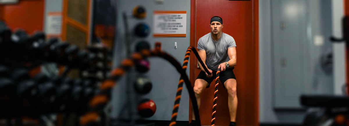 MusclePharm graphic featuring a male athlete performing battle rope exercises in a gym for The 8-Week Summer Shred.